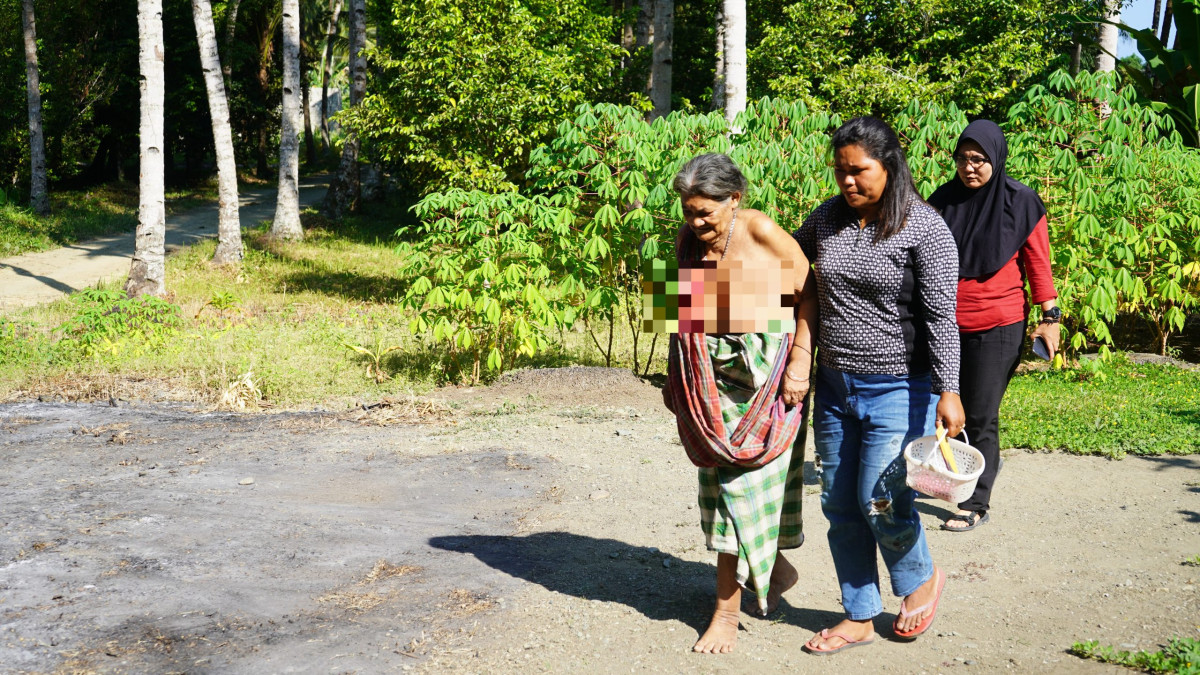 Yuliani Pihang saat mengantarkan Meme mandi di sungai. FOTO : FARIS